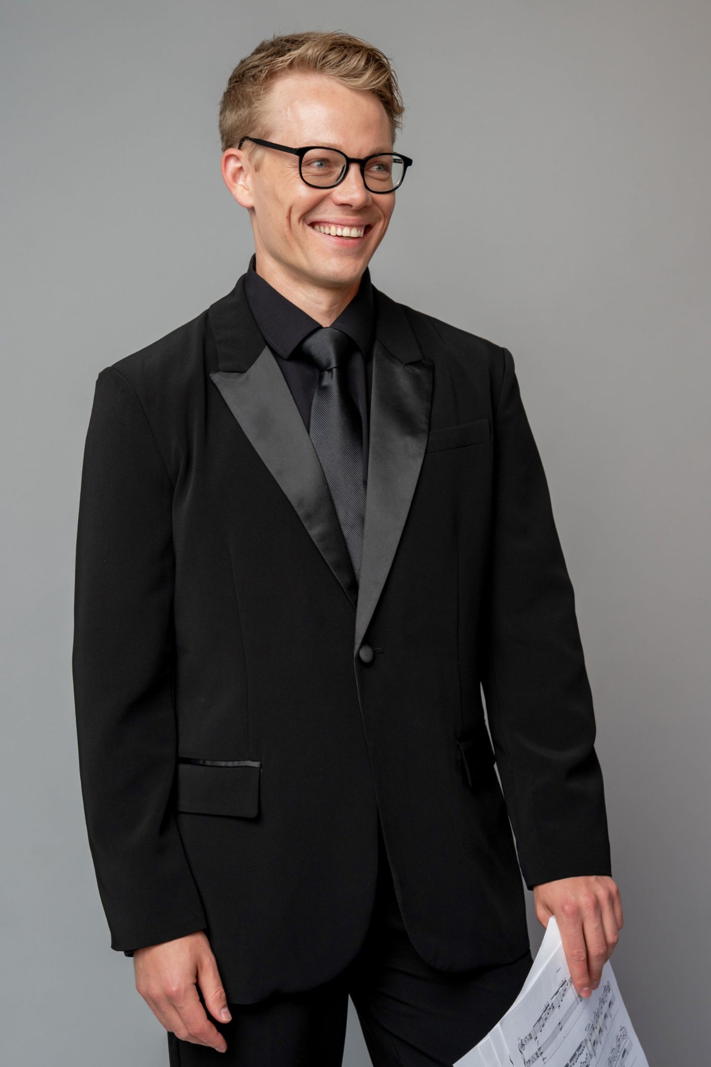 Man wearing a concert black tuxedo with black dress pants