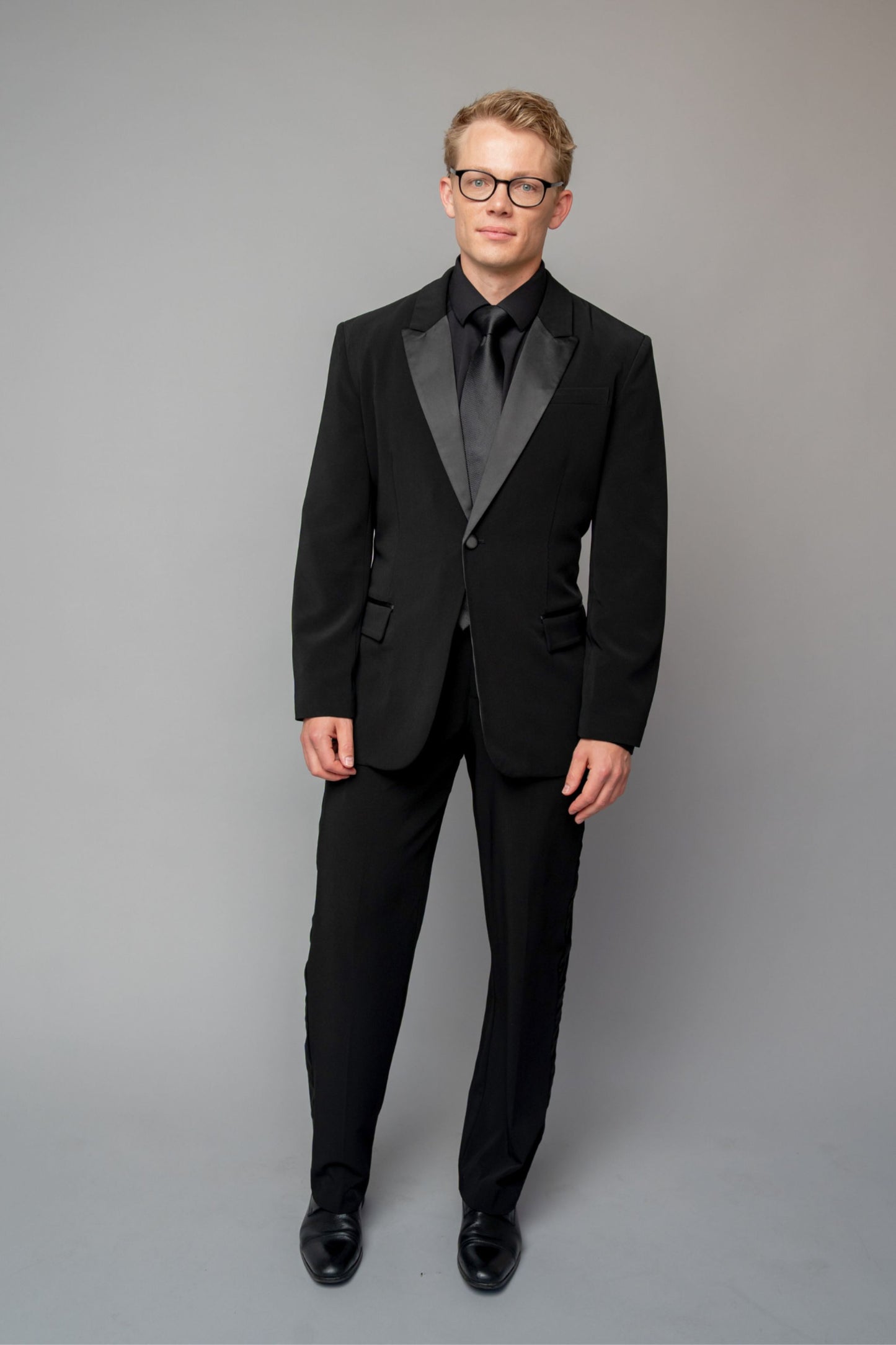 Man wearing a concert black tuxedo with black dress pants
