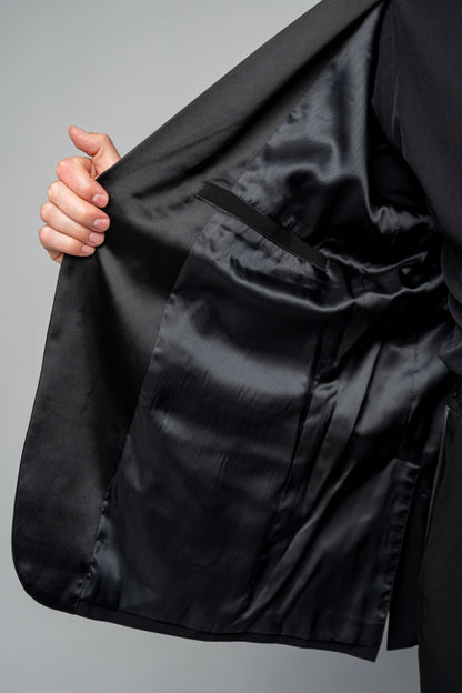 Man wearing a concert black tuxedo with black dress pants